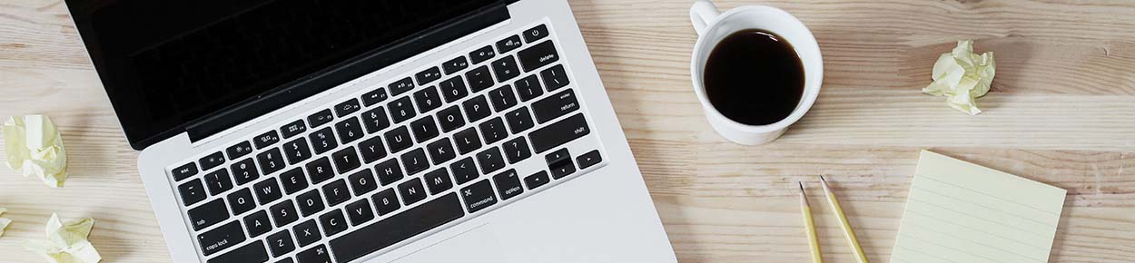 Laptop with coffee and notepad